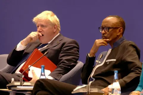 AFP Britain's Prime Minister Boris Johnson yawns as he sits alongside Rwanda's President Paul Kagame.