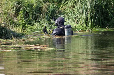 Shaun Whitmore/BBC Diver in river