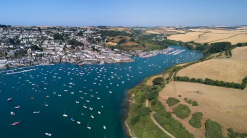 An aerial view over the estuary at Salcombe showing boats on the water and houses in the distance