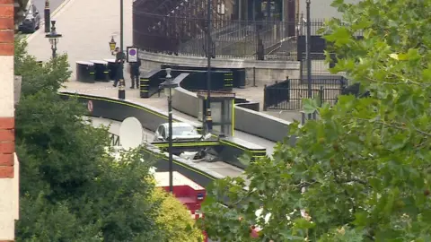 BBC Still frame from BBC News footage of the car which crashed into security barriers outside the Houses of Parliament.