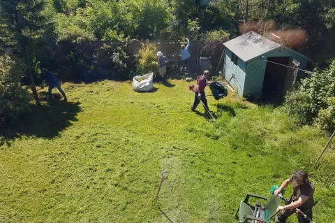 Oshi Owen Croeso group clearing garden