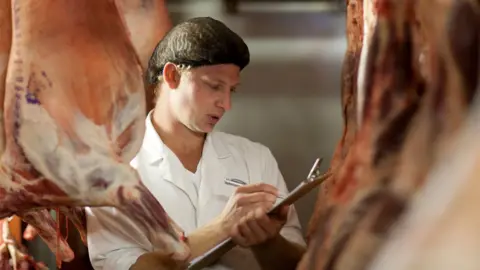 Getty Images Stock image of butcher assessing meat