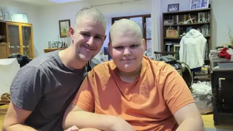 Contributor photo Picture of Louis (right) and his dad Ben smiling at the camera after shaving their heads. 