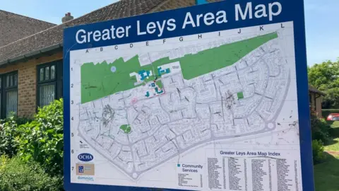 A map displays the Greater Leys area. It shows some green space and lots of dense housing.