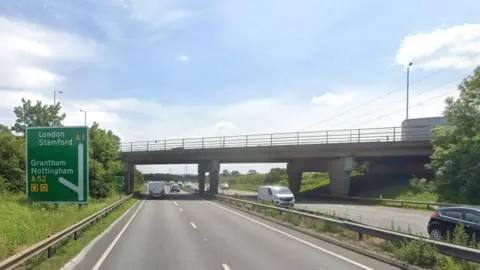 Google A Google street view image of the A1 near to the A52 Spittlegate junction. There is traffic travelling in both directions and the carriageway is separated by a metal barrier.