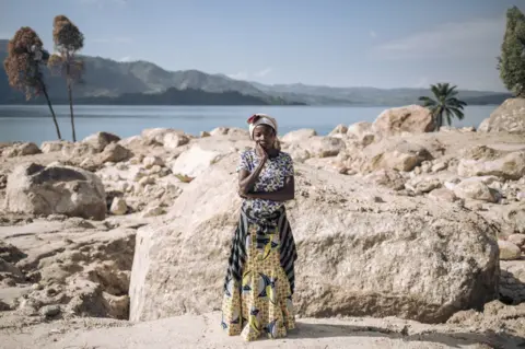 Alexis Huguet/AFP A woman poses on the site of her house that was swept away in floods in Bushushu village, DR Congo - Friday 9 June 2023
