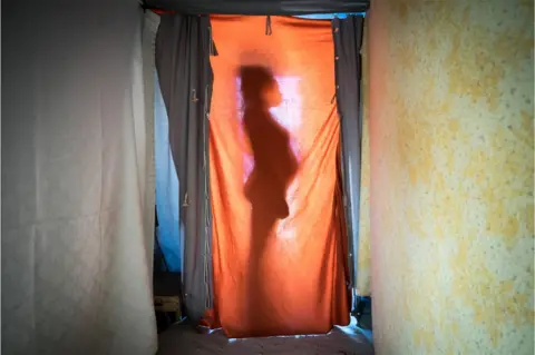 Marco Panzetti Mohamed Fatima is silhouetted against a sheet