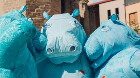 A group of people performing in hippo costumes