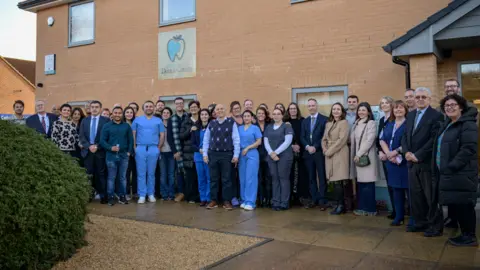 NHS A group of people stood smiling outside a dental centre