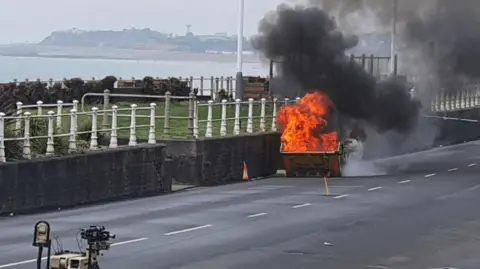 A bin burning with smoke billowing the air.