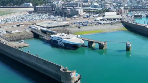 The photo shows a large DFDS boat in Jersey's harbour.