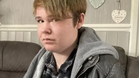 A woman on a sofa is looking at the camera 