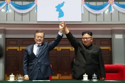 Getty North Korean leader Kim Jong Un, left, and South Korean President Moon Jae-in, right, raise their hands together