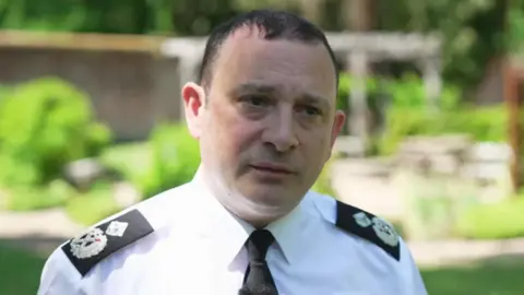 Robert France wearing police uniform and standing in the sunshine
