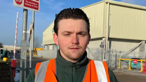 Patrick Powell from Young Lives Foundation stands in a high-vis jacket at his workplace, Countrystyle Recycling in Kemsley