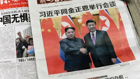 Getty Images Images of Xi Jinping with Kim Jong Un, are displayed at a newspaper stand in Beijing on March 28, 2018