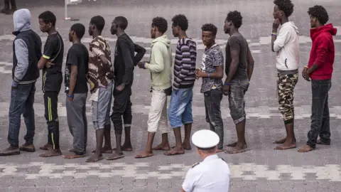 Getty Images Migrants brought ashore in Catania, Italy, 13 Jun 18