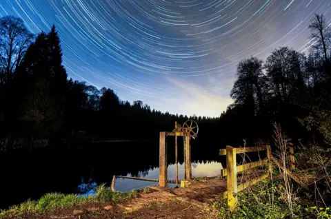 Brian Johns / SWNS Star trail taken over Miserden Lake on the Miserden Estate, at the village of Miserden near Stroud, Gloucestershire