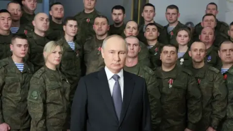 Getty Images Putin backed with military personnel at his New Year's address