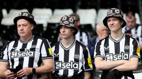 Reuters  Three fans with flowery hats and Newcastle hats