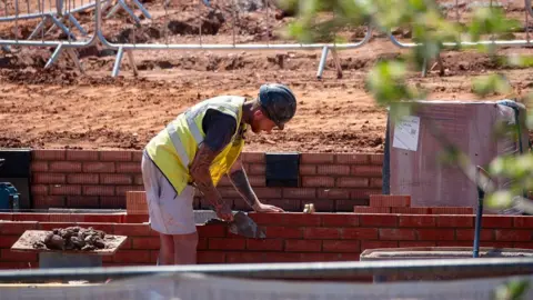 A man laying bricks on a construction site