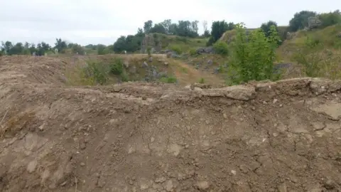 Ken Orpe Mounds of fresh earth in open countryside