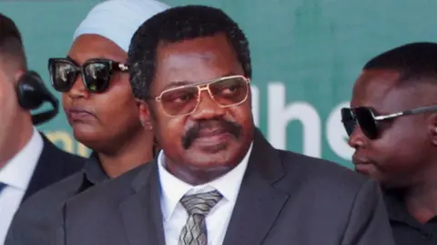 Tanzania's Vice-President Emmanuel Nchimbi in black suit and white shirt attends the inauguration a hydropower project in Rufiji