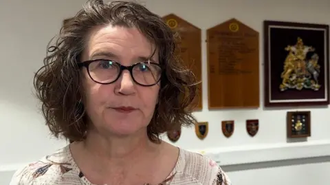 The mayor of Crowborough Town Council, Councillor Natalie Whittle, pictured at the council offices in Crowborough. Natalie has brown shoulder length hair and is wearing glasses. 