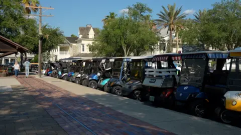 A row of colourful parked golf carts in the Villages