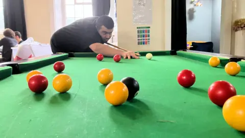 Majib enjoys playing pool at the Clocktower