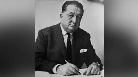 A man in a suit. It is a vintage black and white photograph. 