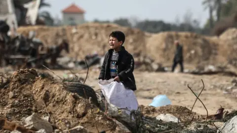 Getty Images A Palestinian boy cries as he stands amid debris in the Maghazi in central Gaza