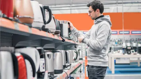 Getty Images Customer choosing a kettle in a shop