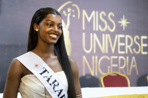     FAWAZ OYEDEJI / AFP Chidimma Adetshina smiles for the cameras. She has long, straight black hair and wears a sash. 