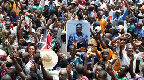 Reuters Mourners gather near a poster of late former Kenyan Prime Minister Raila Odinga, during his funeral service, at Jomo Kenyatta Stadium in Mamboleo, in Kisumu County, Kenya