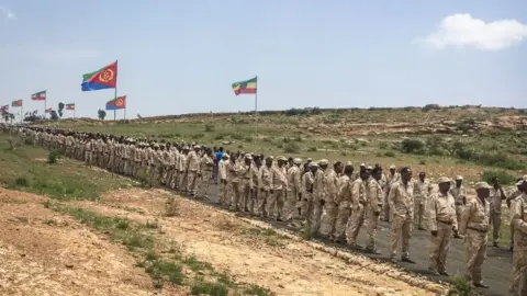 AFP Eritrean soldiers wait in a line on September 11, 2018 to cross the border to attend the border reopening ceremony with Ethiopians as two land border crossings