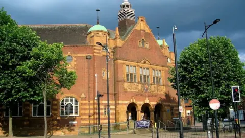 The outside of Wolverhampton Central Library, with arches and red brick walls.