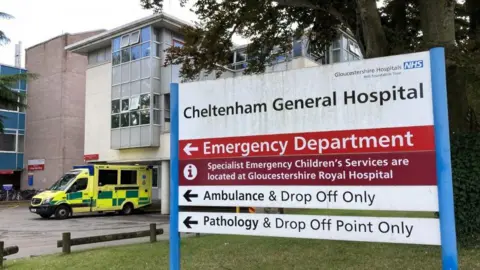 The welcome sign outside Cheltenham General Hospital with an ambulance at the entrance