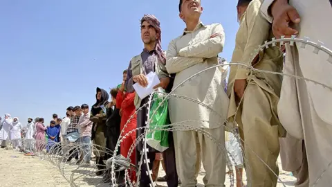 EPA Afghans including those who worked for the US, NATO, Europe Union and the United Nations in Afghanistan wait outside the Hamid Karzai International Airport to flee the country