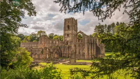 National Trust Fountains Abbey surrounded by greenery