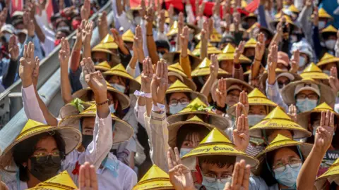 Getty Images Protesters making the three finger salute