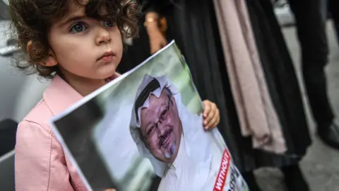 Getty Images A child holds a picture of the missing journalist