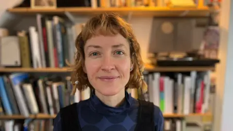 BBC Alison in front of a book shelf