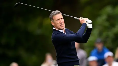 Getty Images Anton Du Beke looks into the distance after striking a golf ball