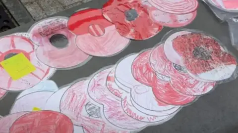 Poppies coloured in by children and laminated in a pile ready to be displayed around a town centre