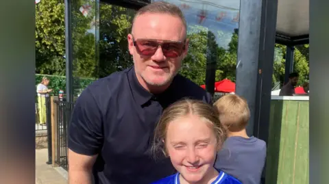 Wayne Rooney with a child
