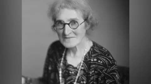 A black and white image of Dr Agnes Arber wearing glasses and looking towards the camera