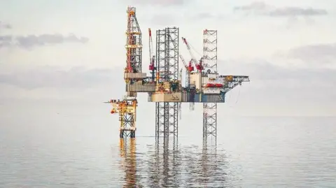 Valaris The Valaris 121 rig photographed in water, with its legs reflected in the sea.