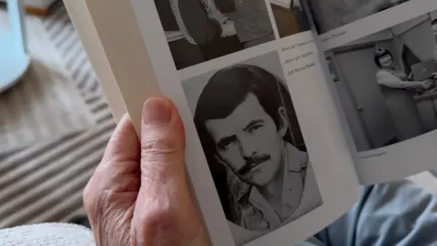 Close up image of a book showing an old black and white photograph of Michael as a young man.