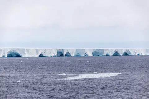 Getty Images A photograph showing the sides of the iceberg with arches and caves